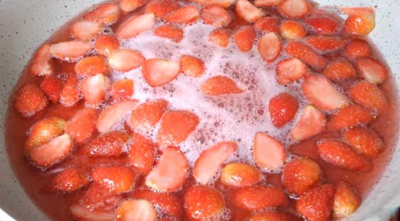 Hỗn hợp dâu tây và đường đang sôi nhẹ trên bếp khi sên mứt