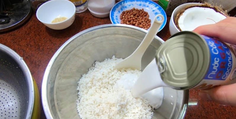 Hỗn hợp nếp, đậu xanh và nước cốt dừa đang được trộn đều trước khi cho vào xửng hấp