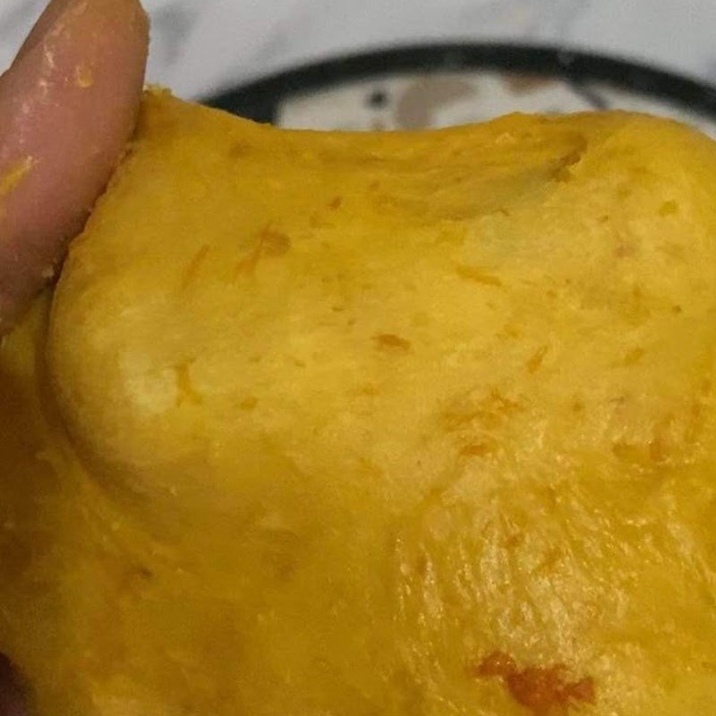 Khối bột bí đỏ dẻo mịn, đã được ủ nở gấp đôi, sẵn sàng để tạo hình bánh