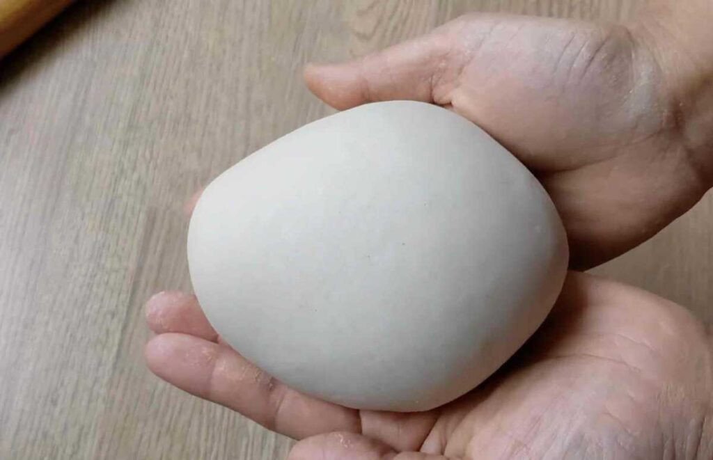 Cách Làm Bánh Hành Chiên Trung Quốc Giòn Rụm, Thơm Ngon Chuẩn Vị Khối bột mì mịn sau khi nhào xong, chuẩn bị cho cách làm bánh hành chiên Trung Quốc.