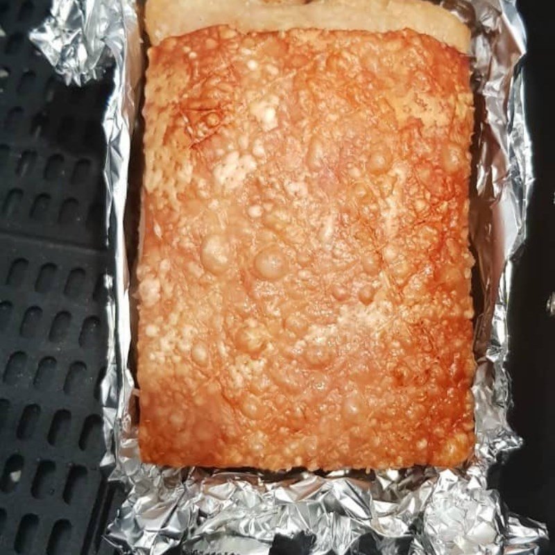 Khứa thịt ba chỉ đã quay sơ và gạt bỏ muối để chuẩn bị cho lần quay giòn bì cuối cùng