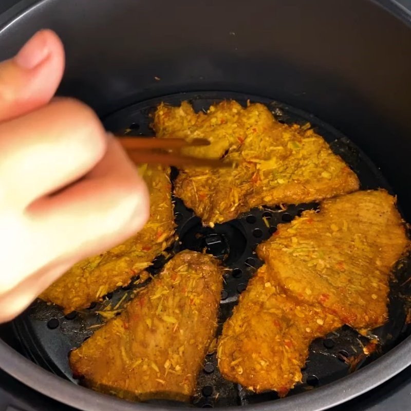 Kiểm tra và lật mặt thịt lợn khi làm khô bằng air fryer