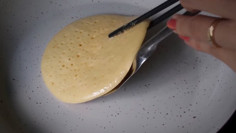 Lật mặt bánh rán Doremon khi bánh đã vàng đều, tiếp tục rán cho chín tới.