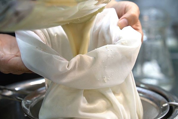 Lọc hỗn hợp sữa hạt sen nhiều lần để đảm bảo độ mịn