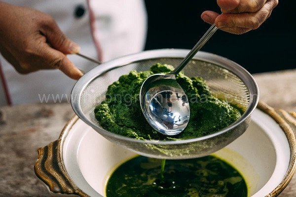 Lọc lấy nước cốt lá dứa tươi để làm bánh đúc