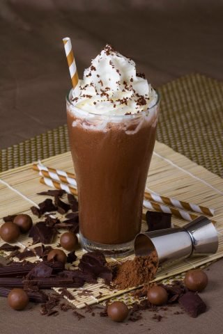 Ly cacao sữa đá mát lạnh với lớp bọt hấp dẫn, thể hiện sự kết hợp hương vị và năng lượng.