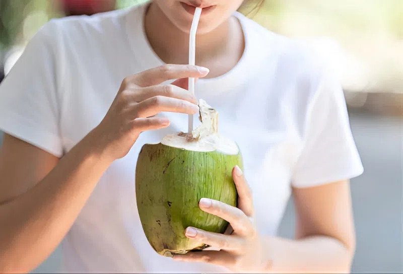 Ly nước dừa giải khát với đá và lát chanh, biểu tượng cho khả năng chống mất nước hiệu quả của nước dừa.