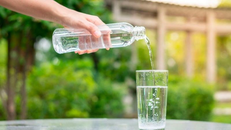 Ly nước lọc bên cạnh hạt hướng dương, thể hiện cách kiểm soát lượng calo hiệu quả