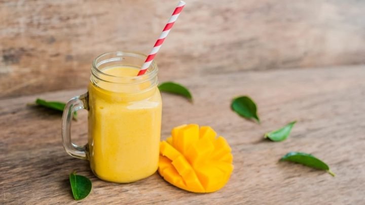Ly sinh tố xoài tươi mát với đá, thể hiện món đồ uống dinh dưỡng.