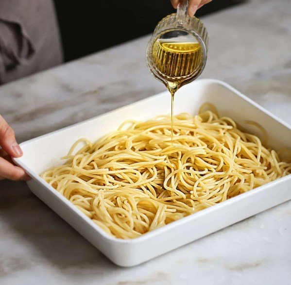 Mì spaghetti được luộc chín tới, xả nước lạnh và trộn dầu oliu