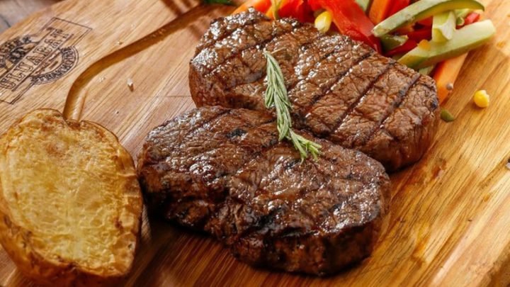 Miếng bò bít tết kiểu phương Tây thơm ngon trên đĩa cùng rau củ