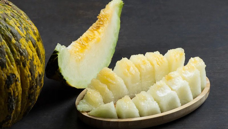 Miếng dưa bở tươi và nguyên quả, thể hiện sự hấp dẫn của dưa bở dầm đường