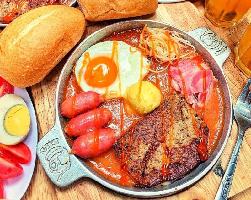 Món bánh mì chảo đầy đặn với trứng, pate và xúc xích nóng hổi