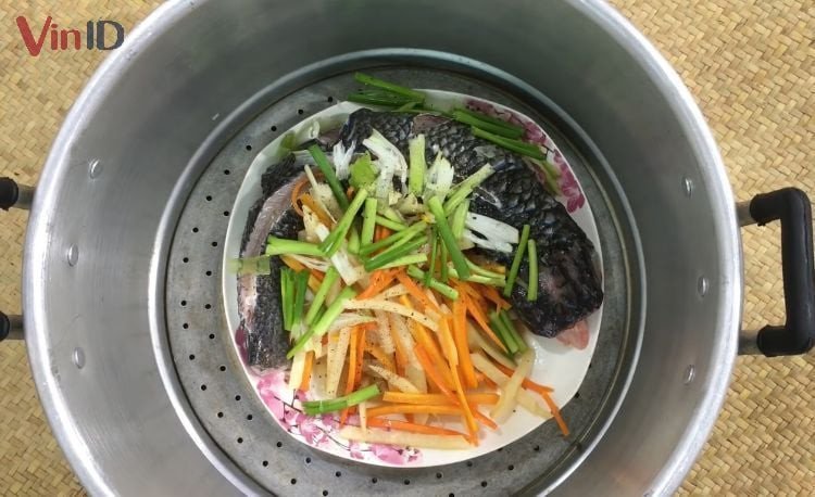 Món cá trắm hấp cuốn bánh tráng đang được hấp chín thơm lừng