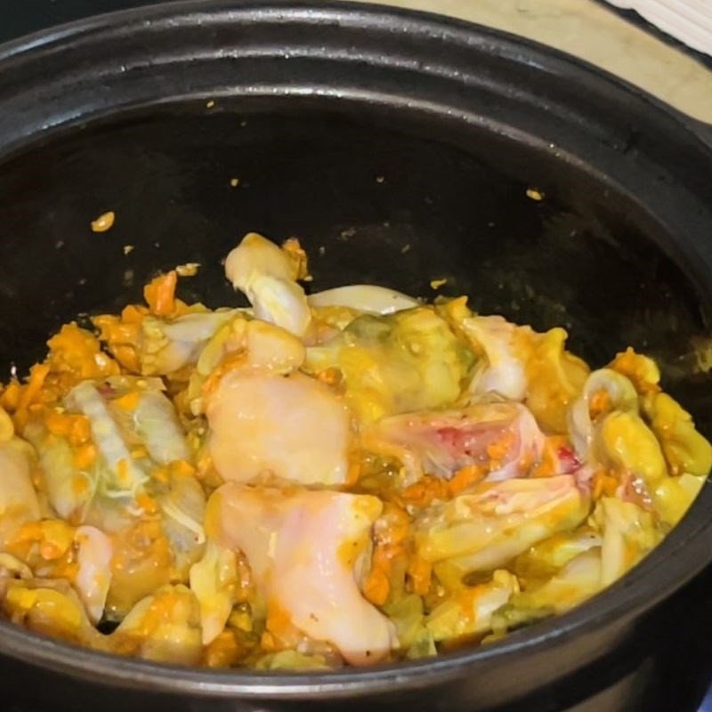 Món ếch xào cà pháo đang sôi trên bếp, ngập trong nước sốt vàng óng