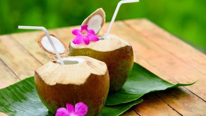 Một cốc nước dừa tươi đặt trên bàn gỗ