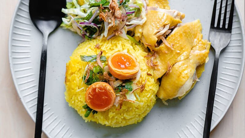 Một đĩa cơm gà Tam Kỳ vàng ươm với thịt gà xé và gỏi hành tây rau răm hấp dẫn