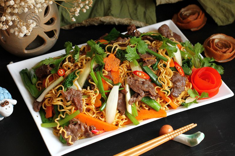 Một đĩa mì xào hấp dẫn được thưởng thức với đũa