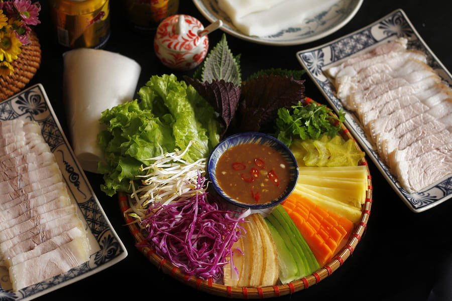 Một đĩa thịt luộc cuốn bánh tráng đầy đủ kèm mắm nêm