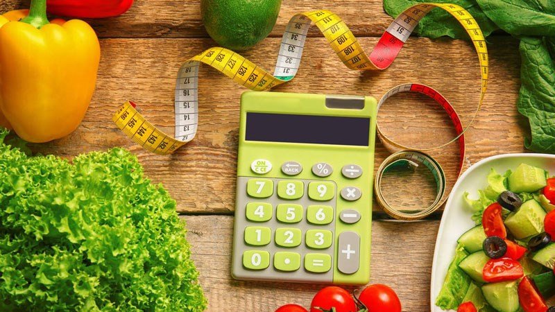 Một người ghi chép lượng calo, thể hiện việc quản lý dinh dưỡng hiệu quả để cân đối năng lượng.