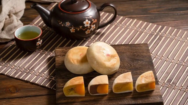 Một người phụ nữ đang suy nghĩ có nên ăn bánh pía mini để tránh tăng cân không.