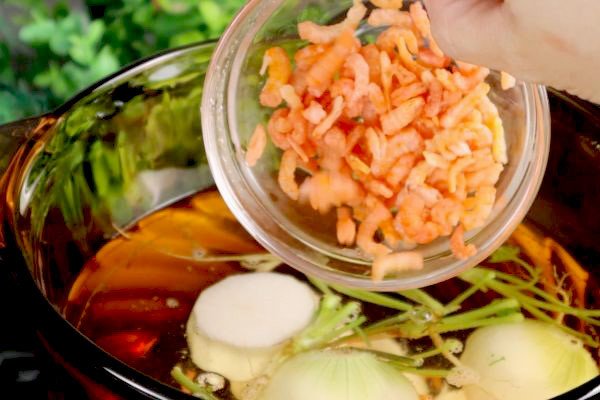 Nấu nước dùng với các loại rau củ, rễ ngò, tôm khô cho cách nấu nui thịt heo