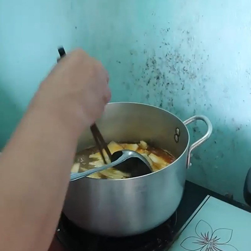 Nêm nếm và hoàn thiện nước lèo bún bò gân với thơm và mắm ruốc