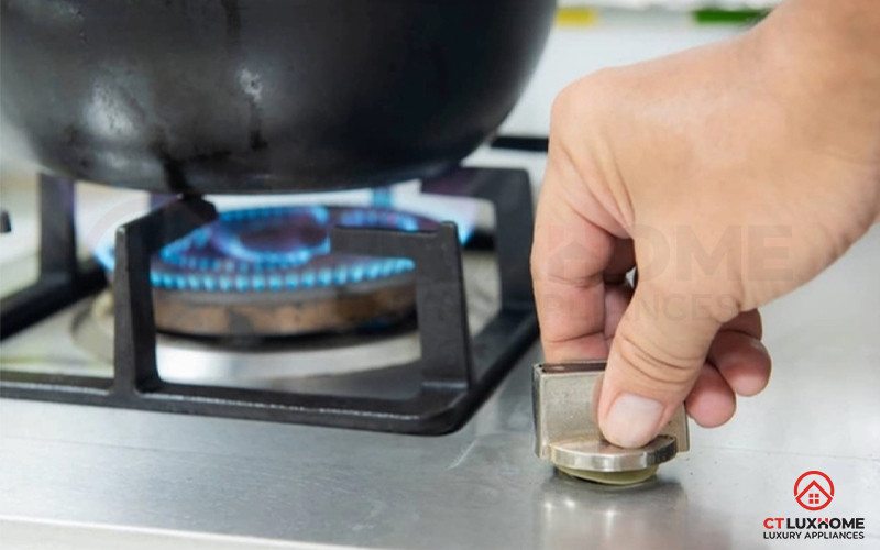 Ngọn lửa xanh từ bếp ga đang đun sôi một nồi nước trong nồi inox.