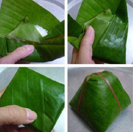 Người đang khéo léo gói bánh giò hình tam giác bằng lá chuối
