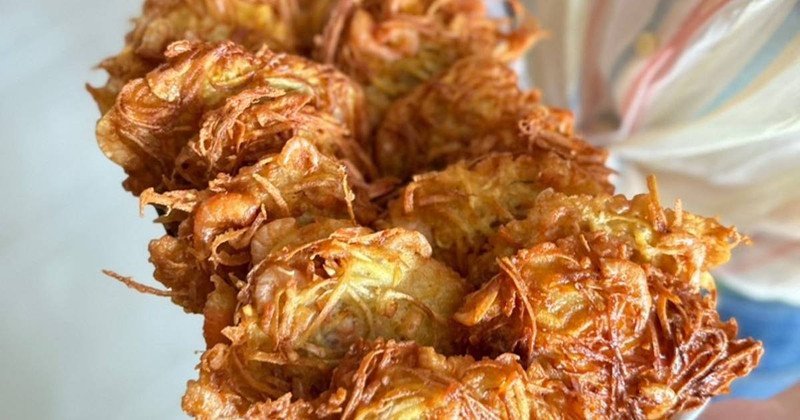 Người đang lo lắng về cân nặng khi cầm đĩa khoai lang chiên, minh họa việc ăn quá nhiều khoai chiên dễ gây tăng cân
