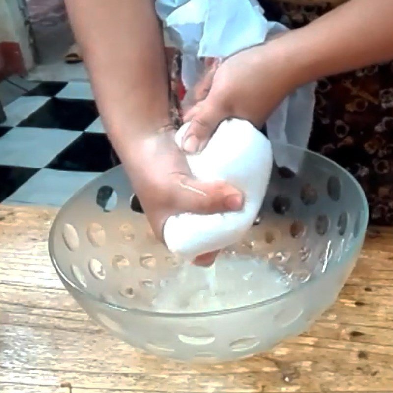 Người nội trợ đang vắt nước từ khoai mì đã xay để lấy bột sắn