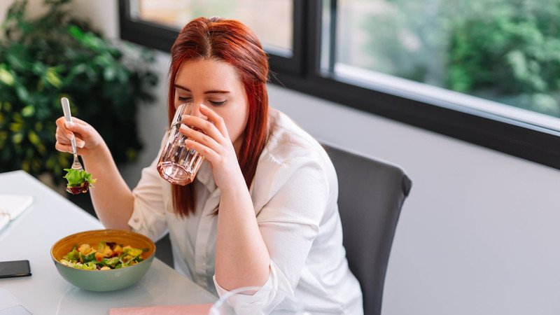 Người phụ nữ cân nhắc khi ăn mứt chùm ruột, lưu ý về khẩu phần và thời điểm tiêu thụ để tránh hấp thụ quá nhiều calo.