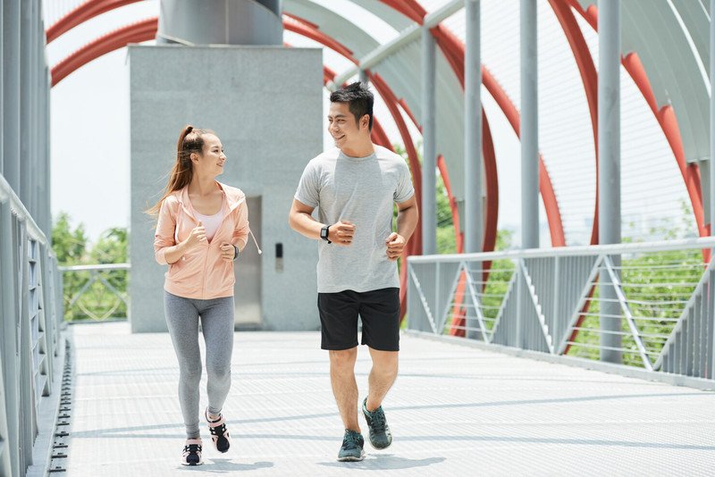 Người phụ nữ chạy bộ ngoài trời, minh họa mức tiêu thụ calo theo trọng lượng