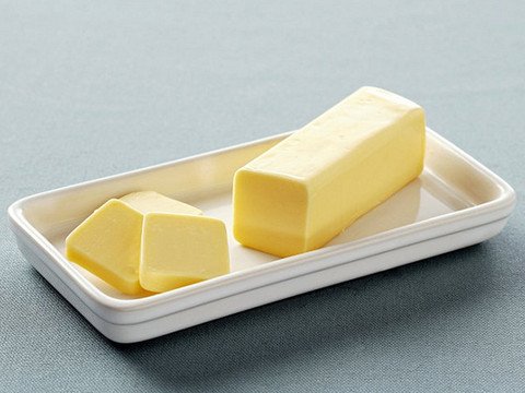 Người phụ nữ đang cầm đĩa bánh mì phết bơ, minh họa cách ăn bơ thực vật không đúng có thể tăng cân