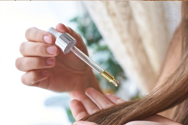 Người phụ nữ đang gội đầu bằng tinh dầu bưởi tự làm.