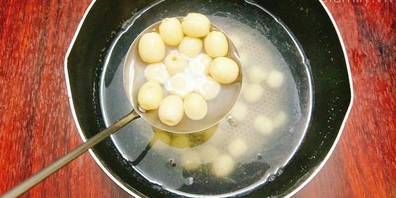 Người phụ nữ đang lựa chọn hạt sen khô chất lượng
