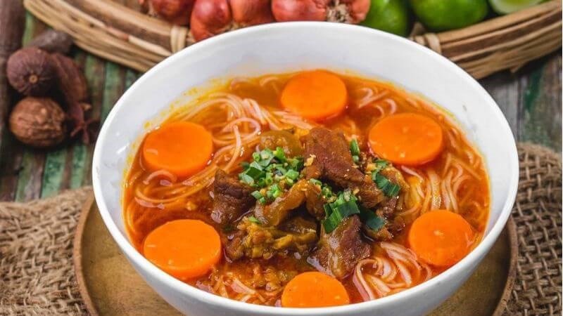 Người phụ nữ đang thưởng thức hủ tiếu, băn khoăn về lượng calo và tăng cân