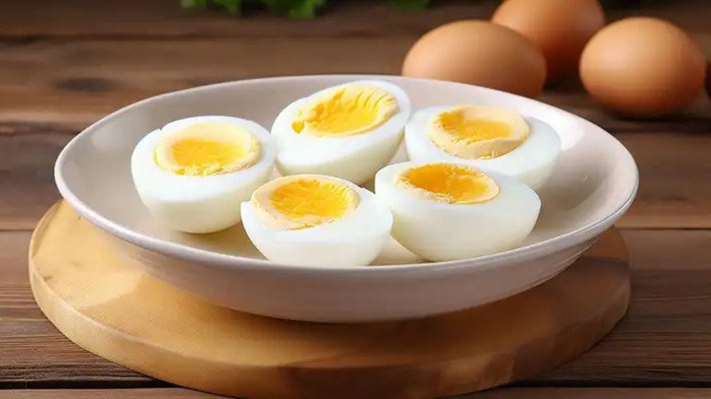 Người phụ nữ đang thưởng thức món trứng gà hấp cùng rau xanh, thể hiện chế độ ăn lành mạnh.