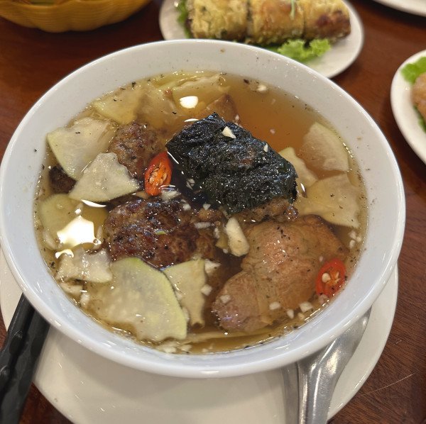 Người phụ nữ đang thưởng thức suất bún chả chấm hấp dẫn