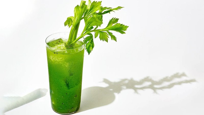 Người phụ nữ hạnh phúc uống ly nước ép cần tây mỗi ngày để giảm mỡ bụng và duy trì vóc dáng