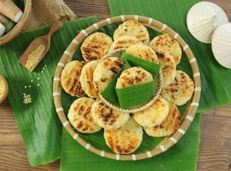 Người phụ nữ lớn tuổi đang cạo vỏ củ sắn tươi để làm bánh sắn