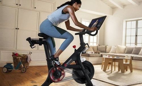 Người phụ nữ tập đạp xe cố định trong nhà để đốt calo