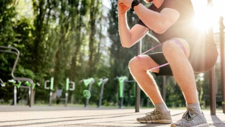 Người phụ nữ tập squat tại công viên, biểu trưng cho việc đứng lên ngồi xuống giảm calo mọi lúc mọi nơi