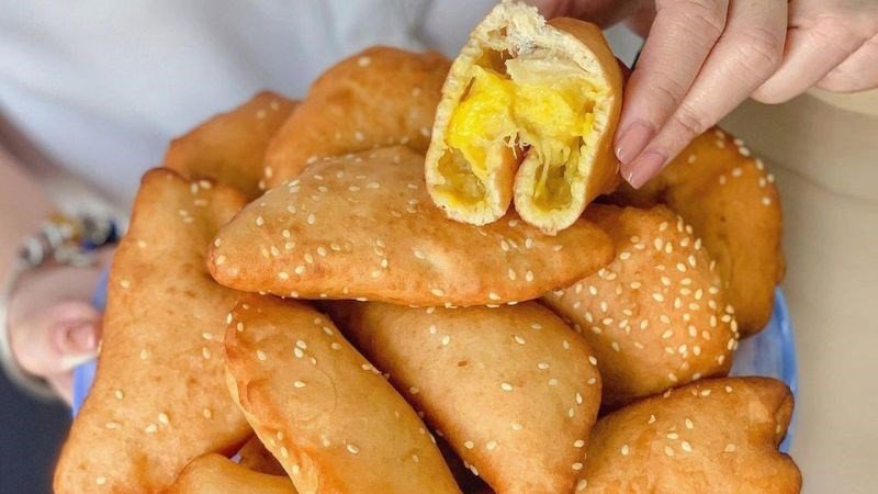 Người phụ nữ thưởng thức bánh tiêu nóng hổi, thể hiện việc ăn uống có chừng mực để duy trì vóc dáng.