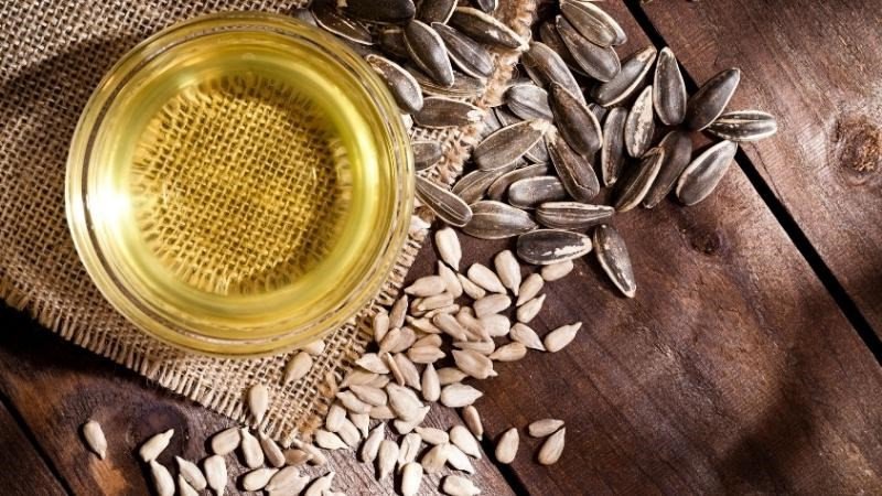 Người phụ nữ với hạt hướng dương, thể hiện sự cân nhắc khi ăn dựa trên điều kiện sức khỏe và lượng calo