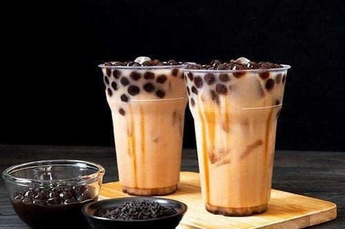 Nguyên liệu pha chế trà sữa như lá trà xanh, sữa, trân châu và đường, tượng trưng cho các thành phần cần lưu ý.
