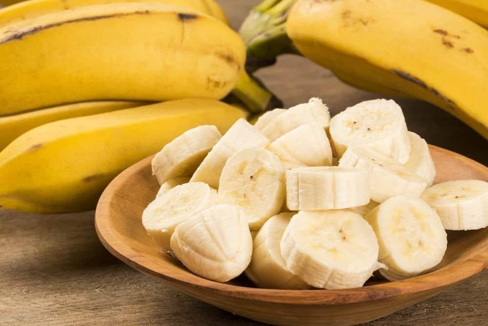 Nhiều quả chuối xanh và vàng được đặt cạnh nhau, minh họa các giai đoạn chín của chuối