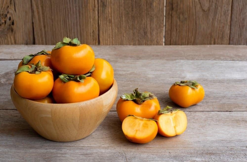 Nhiều quả hồng giòn tươi xếp trên đĩa, nhấn mạnh giá trị dinh dưỡng của hồng giòn