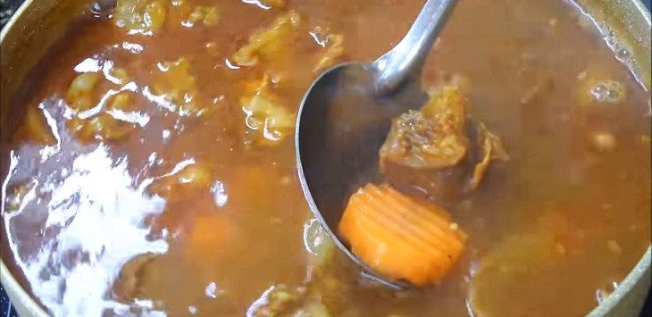 Nồi bò kho đang hầm liu riu với cà rốt và nước dừa tươi ngọt