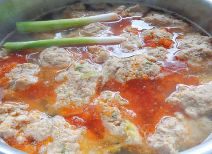 Nồi canh bún đang sôi nhẹ trên bếp, với riêu cua và đậu phụ nổi đều